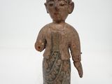 une vieille statue représentant une personne portant un chapeau et une robe
