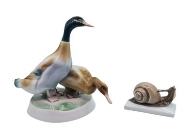 a figurine of a duck and a snail sitting on a table