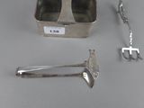 a silver container with a handle and a pair of tonges