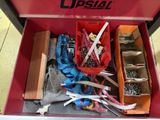a red tool box filled with assorted items on the floor