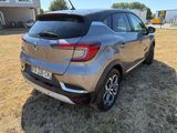 the rear end of a silver car parked in a field