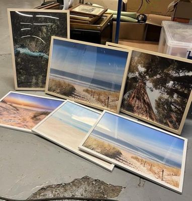 une pile de photos posée par terre à côté d'une pile de livres