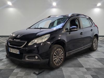 la voiture noire est garée sur un sol en damier dans le garage
