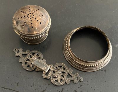 une petite boîte en argent et un petit objet en argent posés sur une table