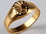 gros plan d'une bague en or sur fond blanc