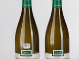 deux bouteilles de vin blanc posées l'une à côté de l'autre sur une table