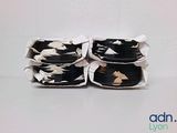 trois rouleaux de tissu noir et blanc emballés dans du papier blanc