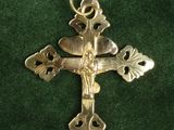 gold cross on a green velvet background with a gold chain