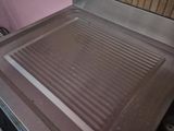 a stove top with a grill on it in a kitchen