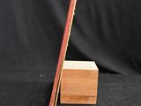 a wooden box with two sticks sticking out of it on a black background