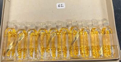 une boîte remplie de flacons en verre contenant des paillettes d'or