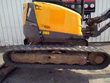a yellow and black bulldozer parked in front of a building