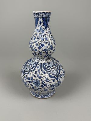 DELFT. Vase double gourde en faïence blanc-bleu à motifs flo…