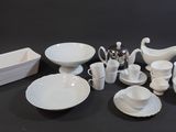 a lot of white dishes and cups on the table