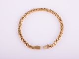 a gold bracelet on a white background