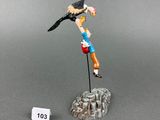 figurine of a bird perched on top of a rock next to a dice