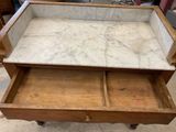 an old wooden dresser with marble top and drawers