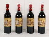 trois bouteilles de vin sont alignées contre un mur blanc