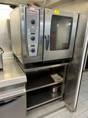 a silver oven sitting in a kitchen with a toaster oven