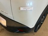 the rear end of a white car with a sticker on it ' s bumper