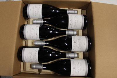 six bouteilles de vin dans un carton sur une table