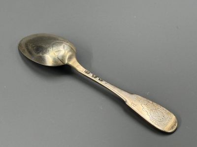 une vieille cuillère au manche en argent posée sur une table