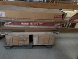 un homme debout à côté d'une pile de cartons posée sur une palette