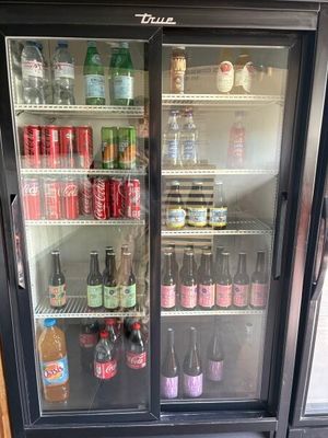 Des bouteilles de soda et de boissons gazeuses sont exposées dans une armoire réfrigérée
