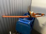 an orange and black chainsaw sitting on top of a blue cart