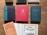 plusieurs livres posés sur une table en bois, dont l'un est ouvert et l'autre fermé