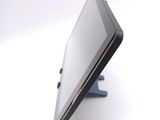 a tablet computer sitting on a stand on a white surface
