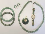 un collier, un bracelet, une bague et d'autres bijoux posés sur une table