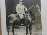 a picture of a man sitting on top of a horse