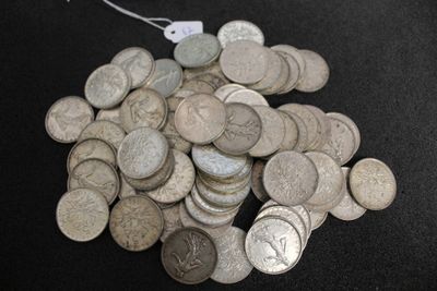 a pile of silver coins on a black surface