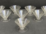 six clear glass goblets sitting on top of a table