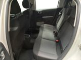 the back seats of a car with a remote control in the passenger seat
