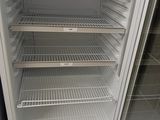 a white refrigerator that is open and empty in the room