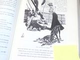un livre ouvert sur lequel figure l'image d'un homme et d'un chien