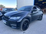 a black bmw x6 parked in front of a building