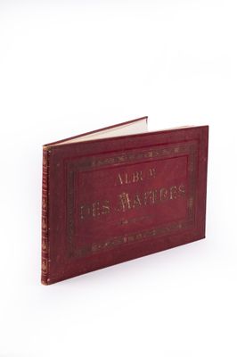 un vieux livre rouge, sur lequel on voit des inscriptions, posé sur une surface blanche