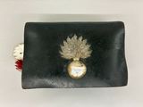 un petit sac à main noir orné d'un motif de feuilles dorées
