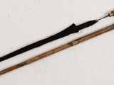 pair of wooden walking canes with black handles on a white surface