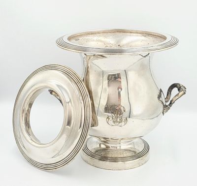 une coupe ancienne en métal argenté avec un couvercle, posée sur un socle