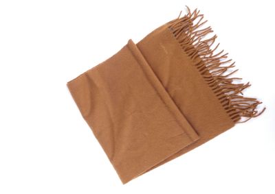 a brown scarf with fringes on it on a white surface