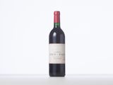 a close up of a bottle of red wine on a table