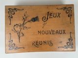wooden box with writing on it that says jeux, nouveauux, reunis, and a rose