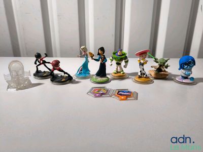Des figurines Disney sont alignées sur une table blanche