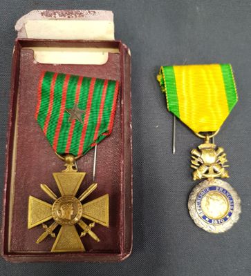 deux médailles et une médaille dans un écrin posé sur une table