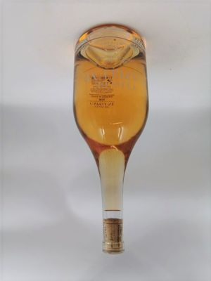 une photo d'une bouteille d'alcool posée sur une table blanche