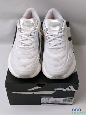 une paire de baskets blanches posée sur une boîte